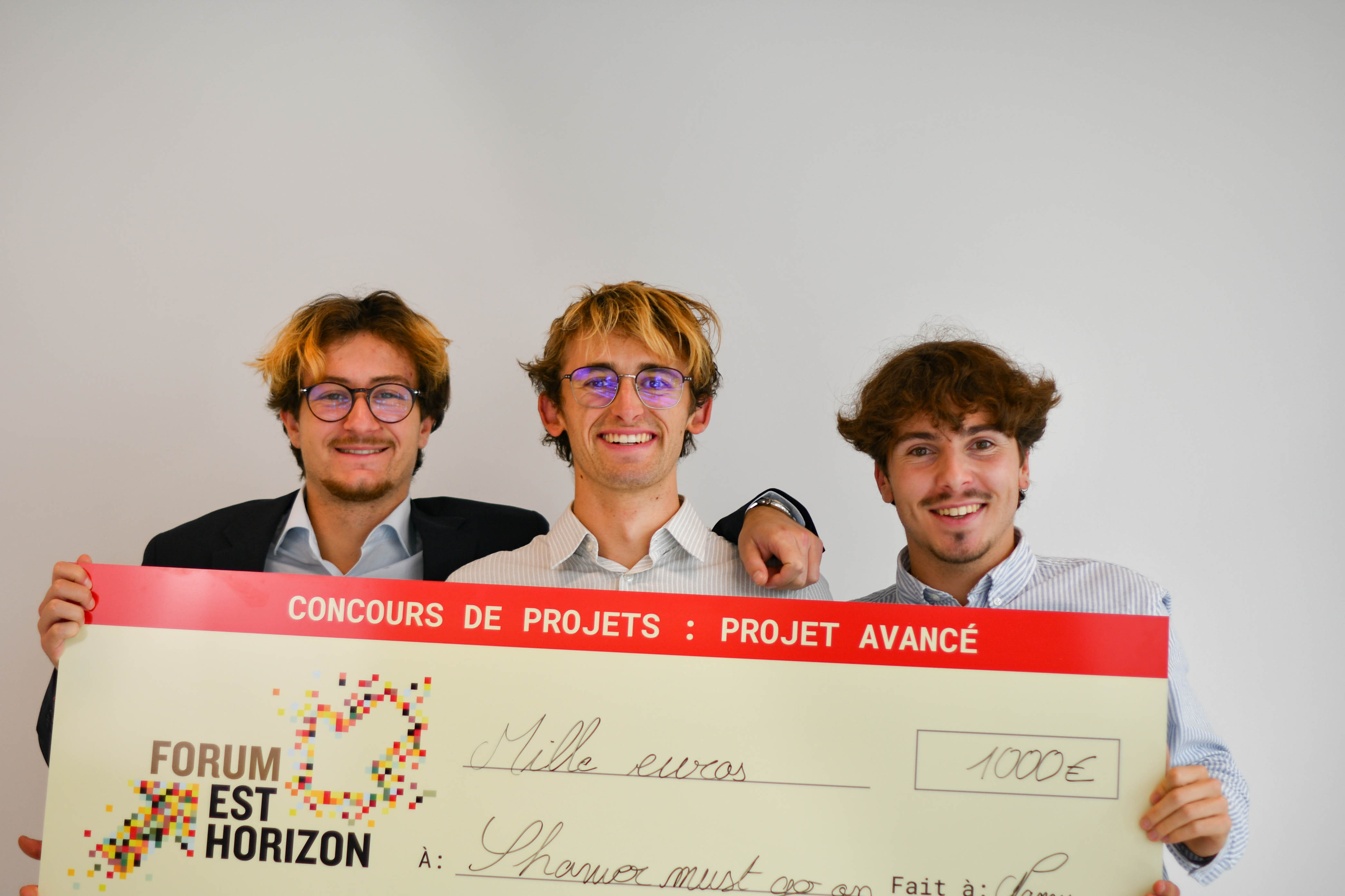 Chèque géant porté par les gagnants du concours